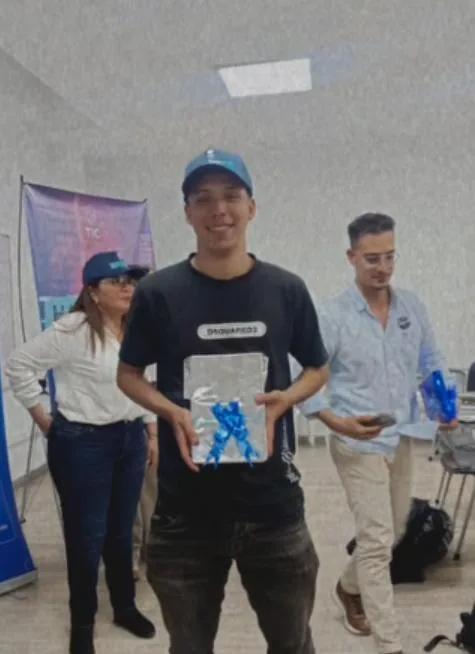 Juan Felipe González sosteniendo el premio del hackathon